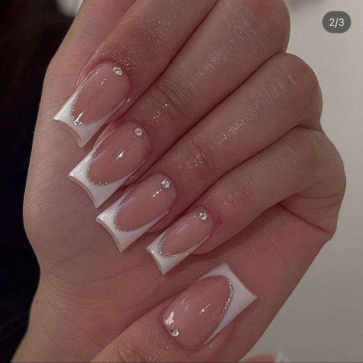 Chic Geometric Nail Design in Glossy Nude and White with Subtle Rhinestone Accents.