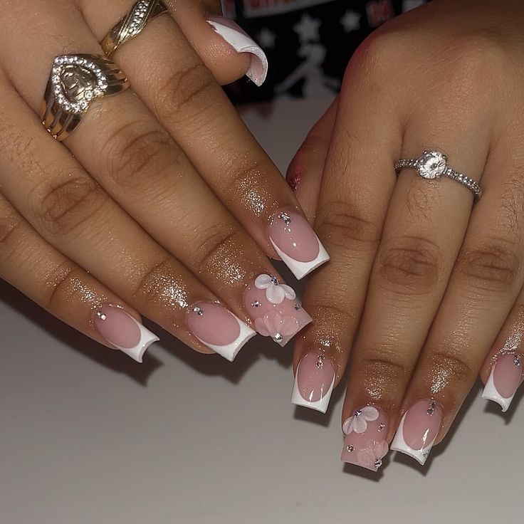 Chic Soft Pink Nail Design with White Tips, Floral Accents, and Rhinestones for Special Occasions