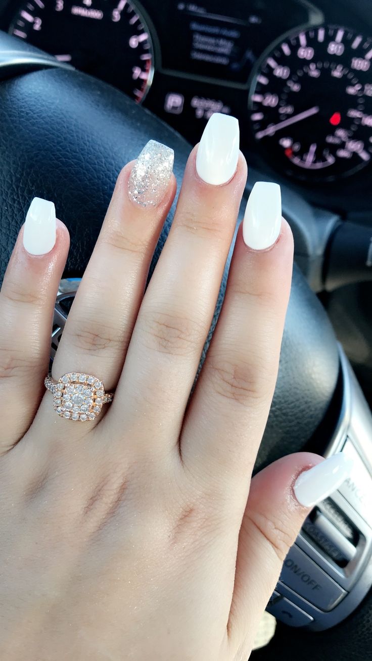 Chic Glossy White Nail Design with Sparkling Accent and Statement Ring.