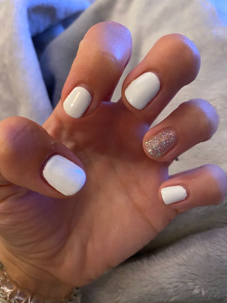 Elegant Chic White Nail Design with Glamorous Glitter Accent.