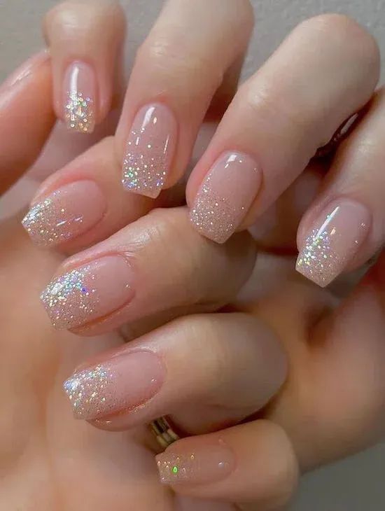 Elegant Gradient Nails: Soft Nude Base with Sparkling Glitter Tips for Versatile Glam.