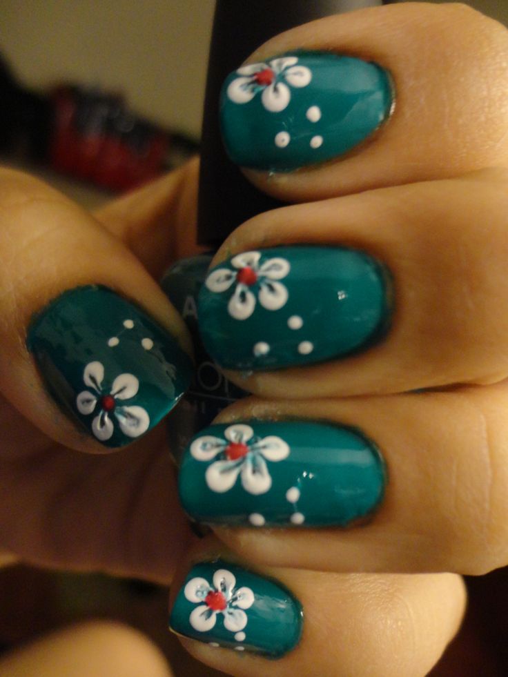 Vibrant Turquoise Nail Design with Delicate White Flowers and Cheerful Red Accents.