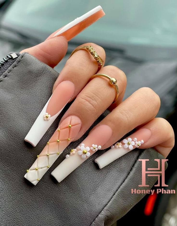 Elegant Long Nails with Nude and White Polish: A Chic Blend of Floral and Golden Accents