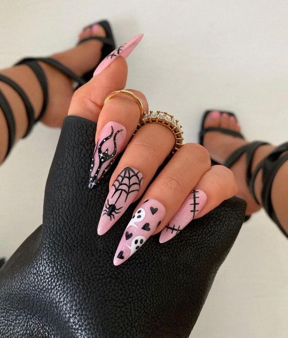 Spooky-themed nail design blends black and pink with intricate patterns for a bold, dramatic look.