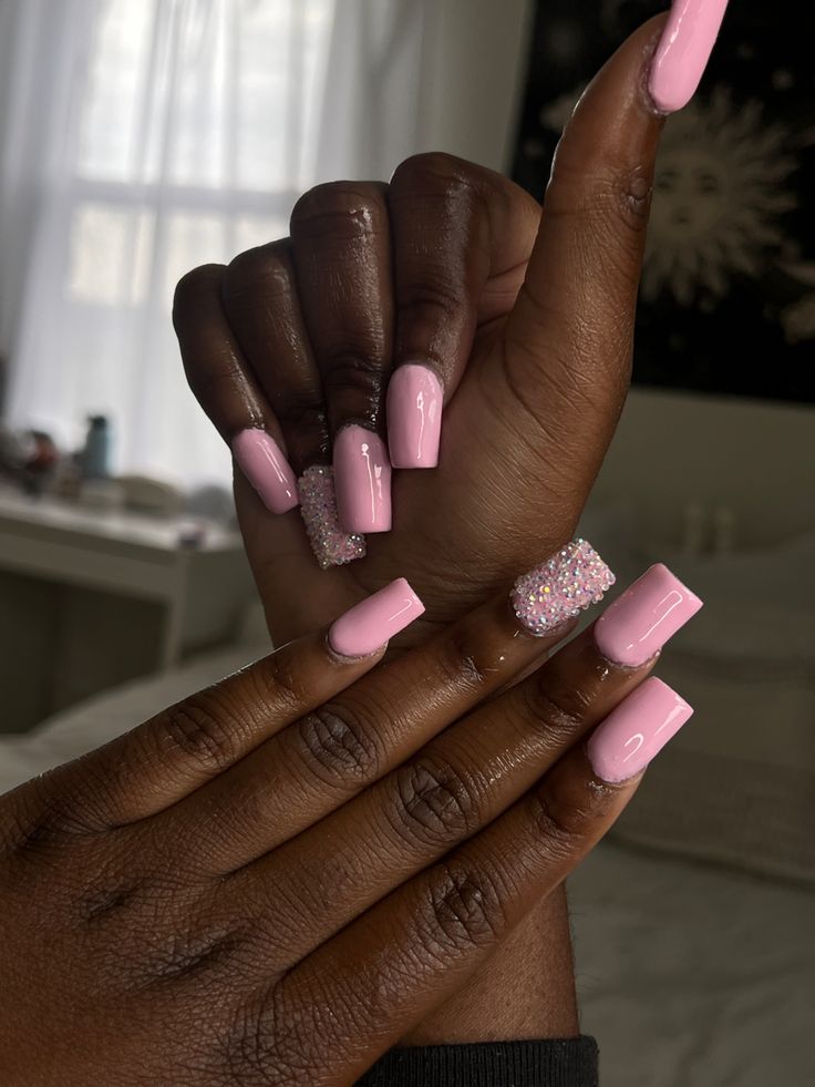 Chic Pink Nails with Glossy Finish and Glitter Accent for Any Occasion.