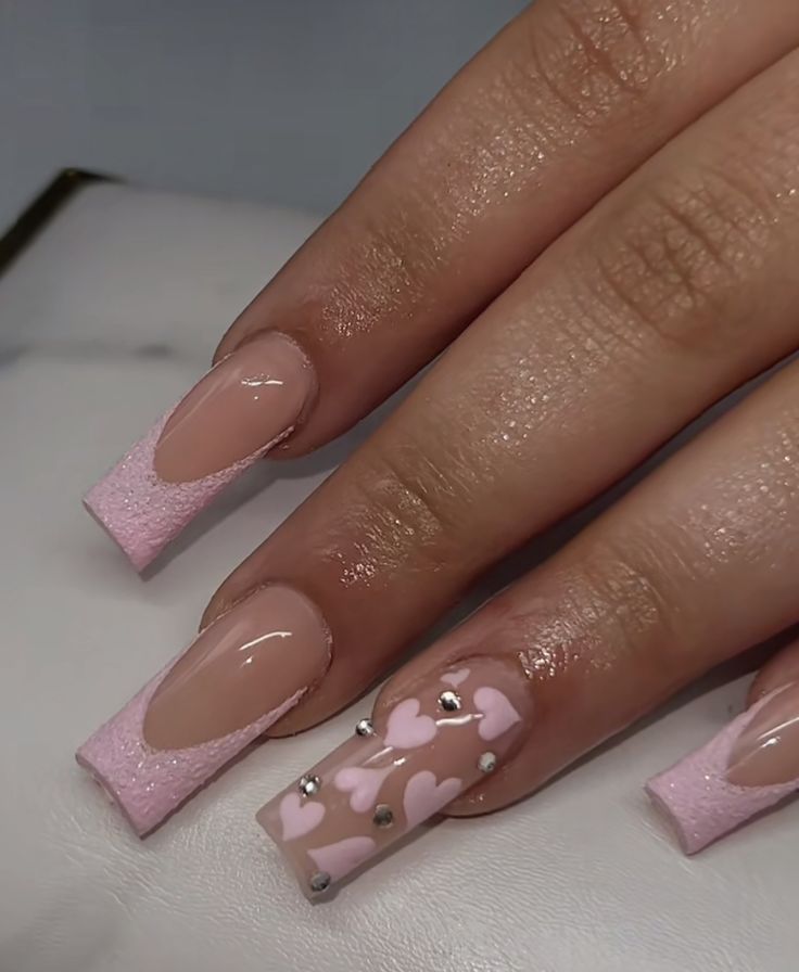 Chic Pink Nail Design: Textured Finishes and Heart Embellishments for a Playful Look.