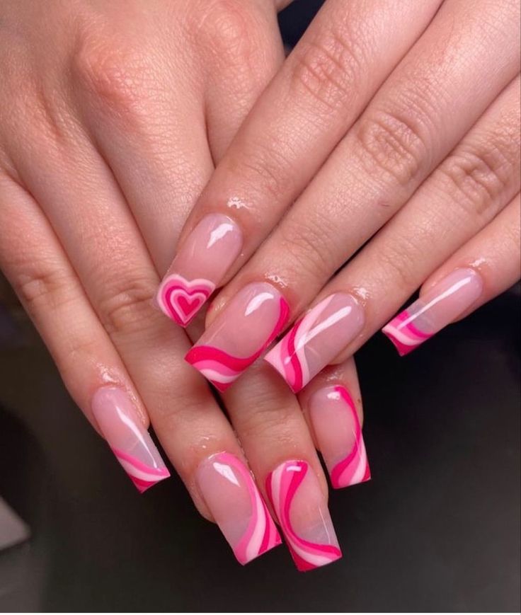 Chic Nail Design: Clear Polish with Vibrant Pink Heart Motifs and Swirls for a Playful Elegance.