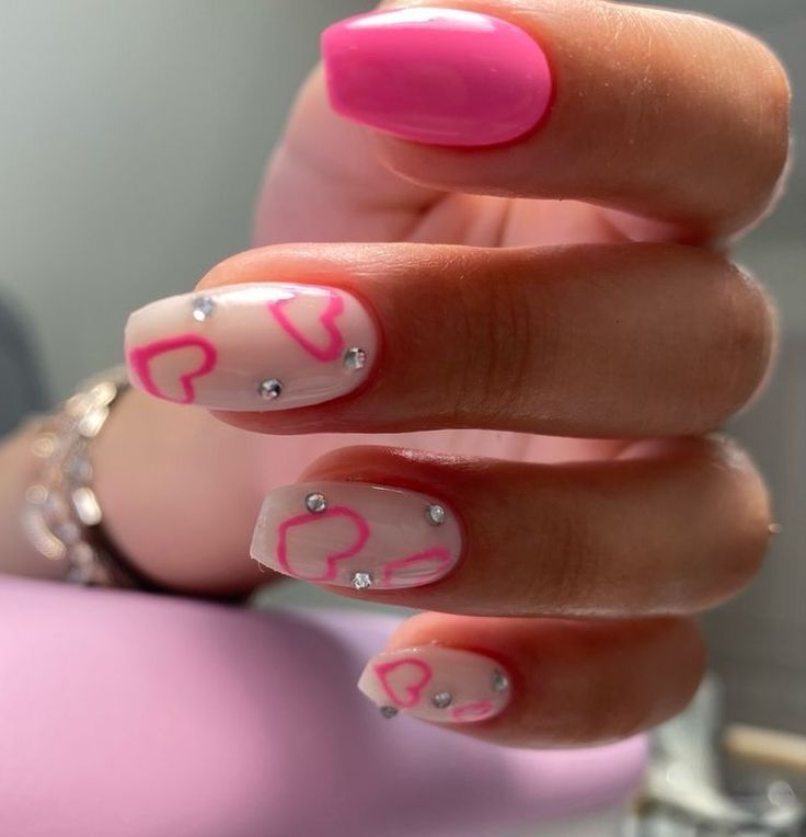 Playful Pink Nail Design with Hearts and Rhinestones for a Flirty Look