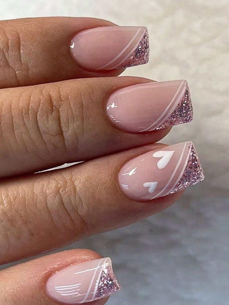 Charming Soft Pink Nail Design with Gradient, Heart Accents, and Glitter Tips