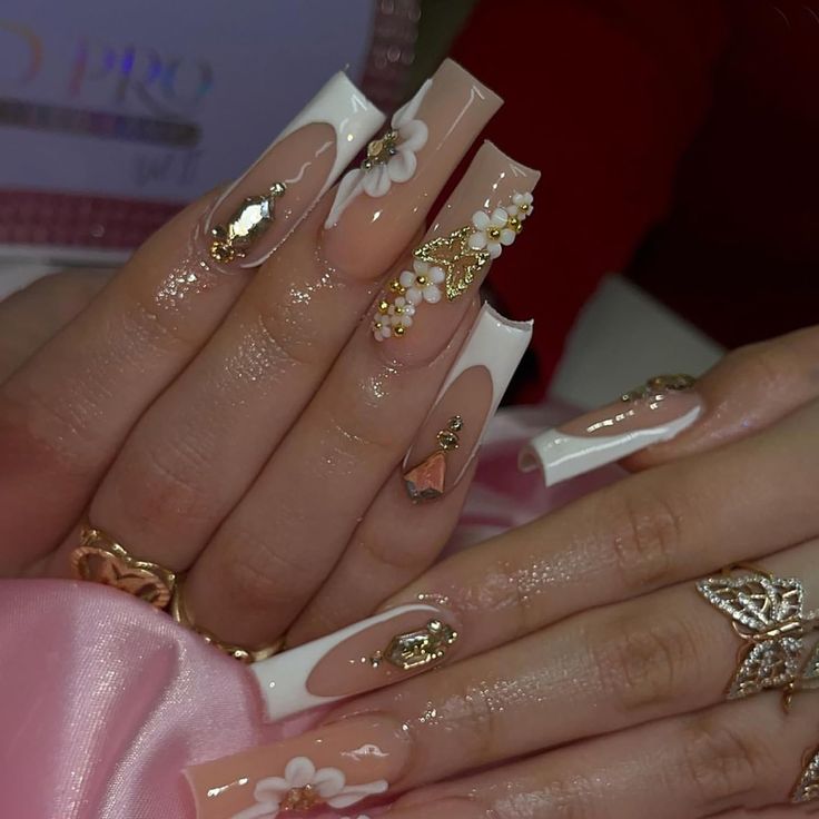 Luxurious Nude and White Nail Design with Floral Embellishments and Gold Accents