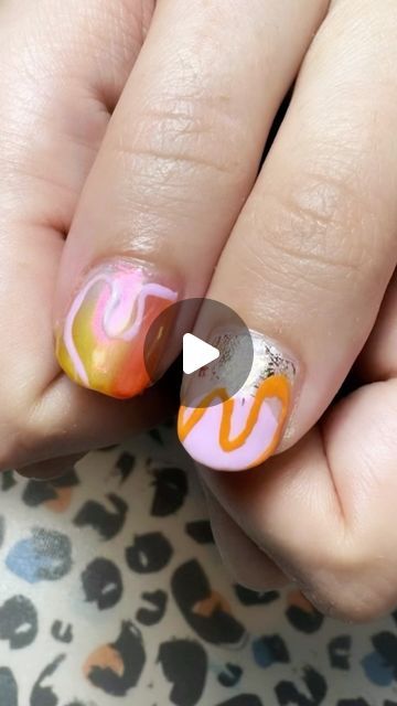 Playful Vibrant Nail Design with Fluid Swirls and Glam Metallic Accent.