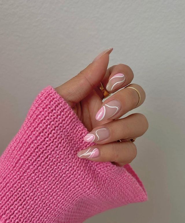 Elegant Soft Pink and White Nail Design with Artistic Waves and Swirls.