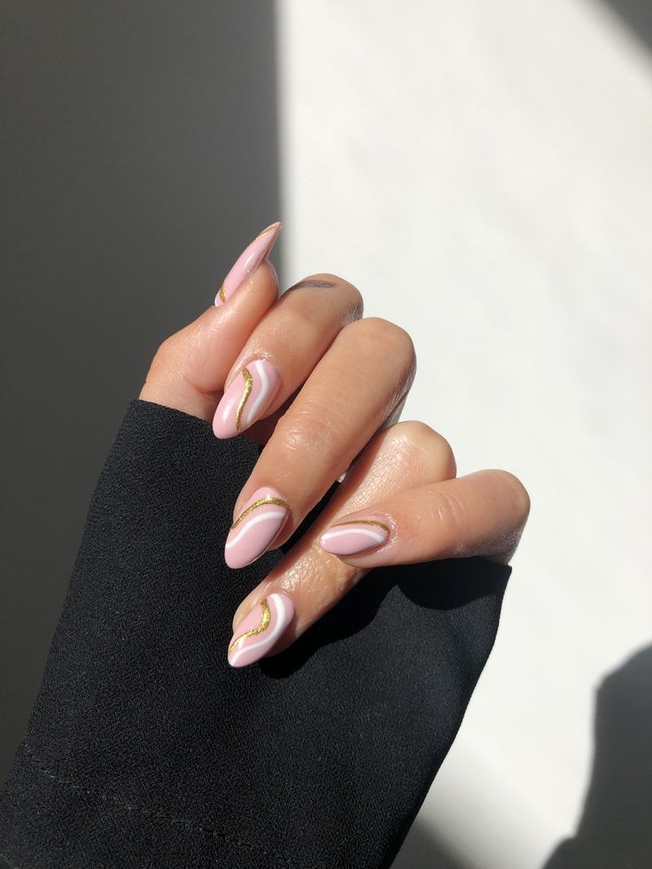 Sophisticated Almond-Shaped Nail Design: Soft Pink Base with Intricate Gold Accents and Delicate Swirl Patterns