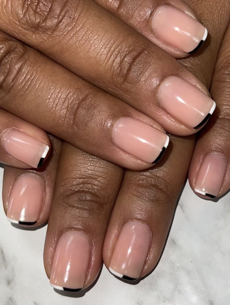 Chic Modern French Manicure: Soft Nude Base with Striking Black Tips and Glossy Finish.