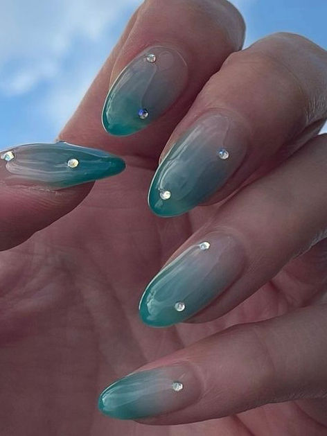 Teal to Clear Gradient Nail Design with Sparkling Gems for a Sophisticated Ocean-Inspired Look.