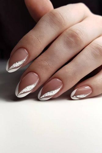 Elegant Almond-Shaped Nails with Nude Base, White Tips, and Silver Chevron Accents.