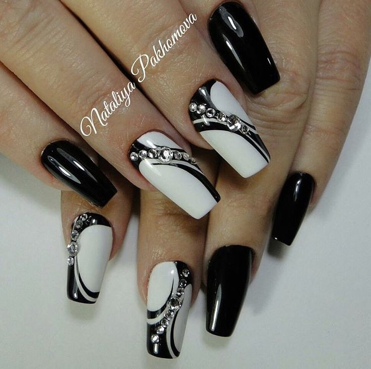 Sophisticated Black and White Nail Design with Glossy, Matte Finishes and Rhinestone Accents.