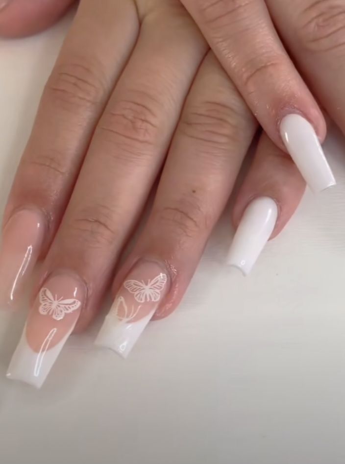 Sophisticated Nail Design with Whimsical Butterfly Motifs in Soft White and Translucent Shades.