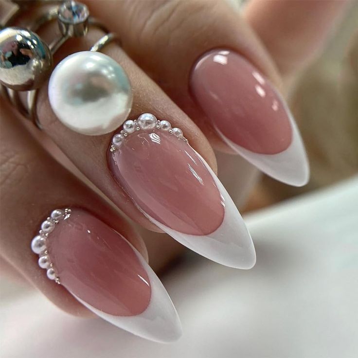 Sophisticated Almond-Shaped Nails: Soft Pink Base with Glossy Finish and Elegant Pearl Accents.