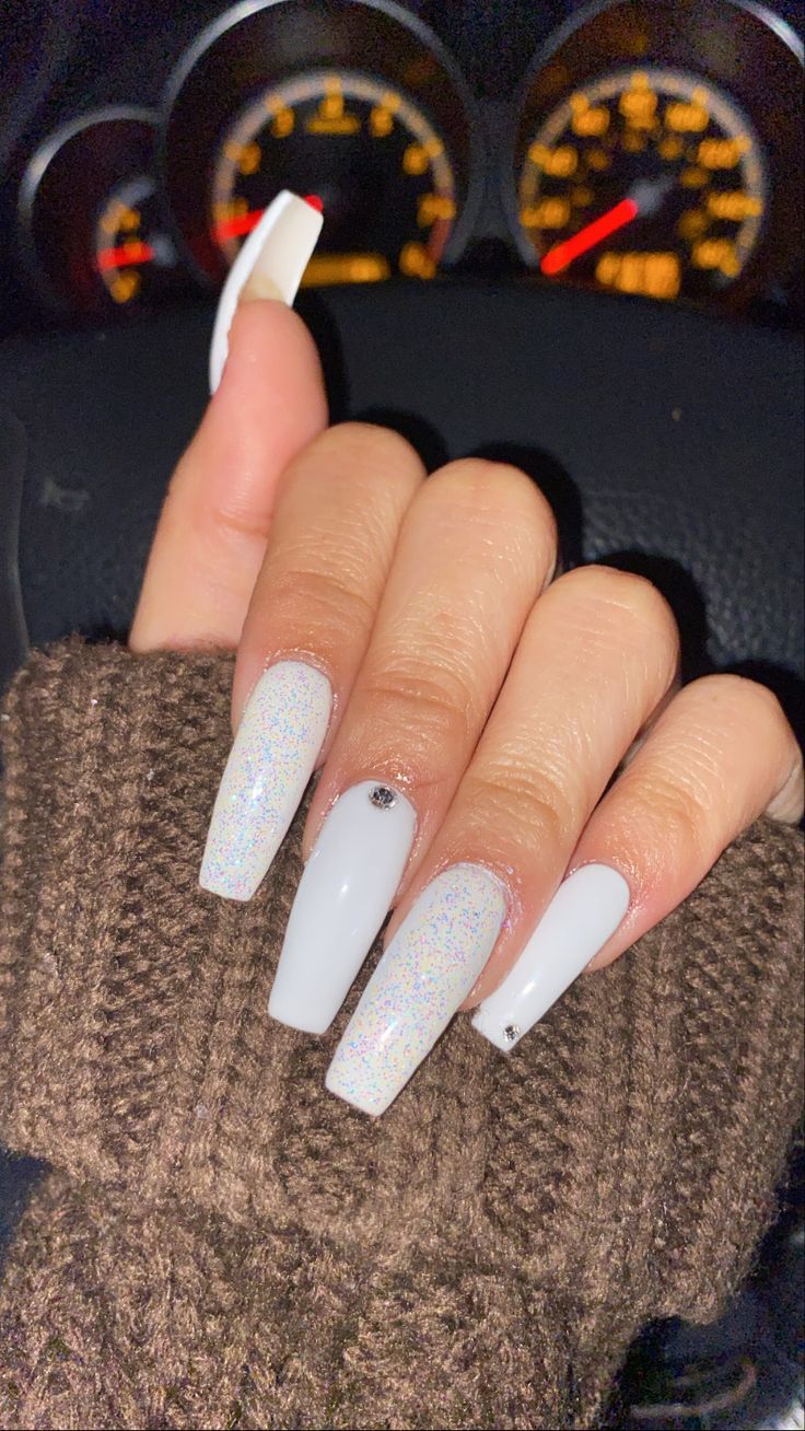 Glamorous Glossy White Long Nails with Holographic Sparkle and Rhinestone Accents.