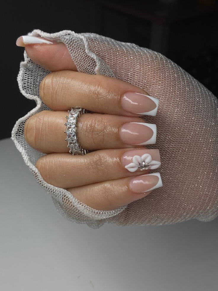 Elegant Oval French Tip Nails with Floral Accent for Everyday Sophistication.