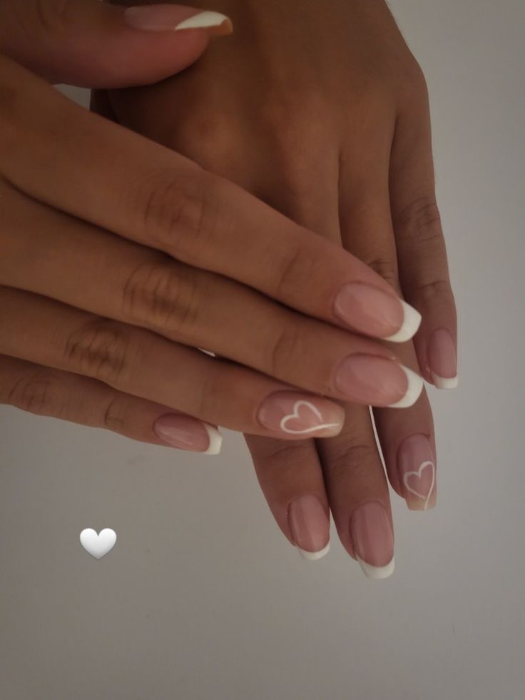 Chic Nude French Tip Nails with Whimsical Heart Accents.