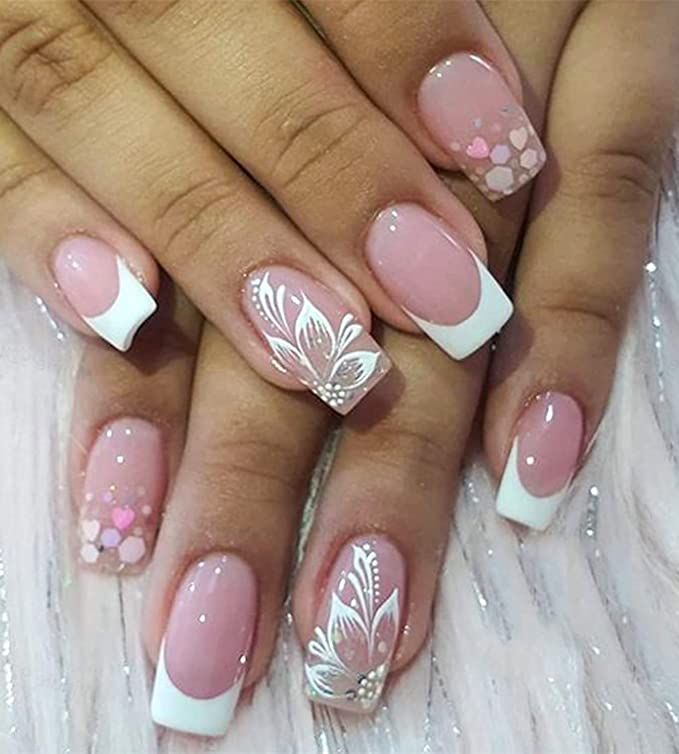 Chic Soft Pink and White Nail Design with Floral Patterns and Pastel Shapes.