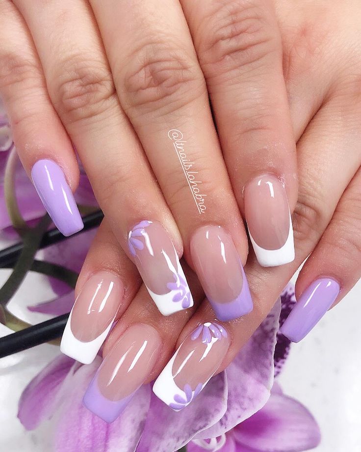 Elegant Lavender and White French Tip Nails with Delicate Floral Accents for Spring.