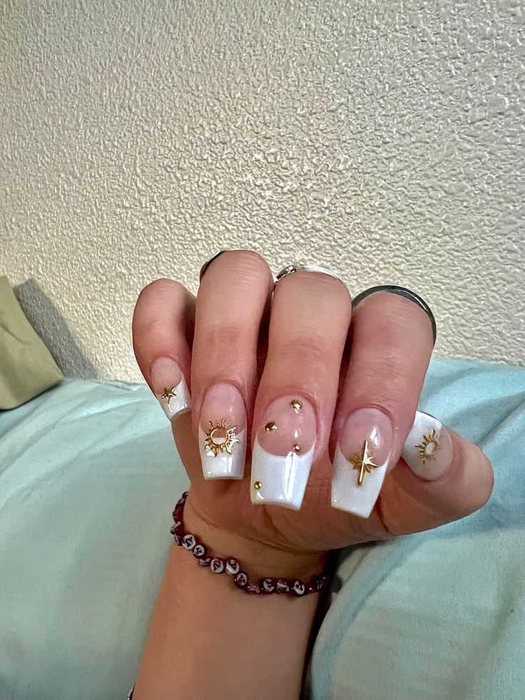 Sophisticated French Manicure with Whimsical Celestial Gold Accents on a Clean White Base.