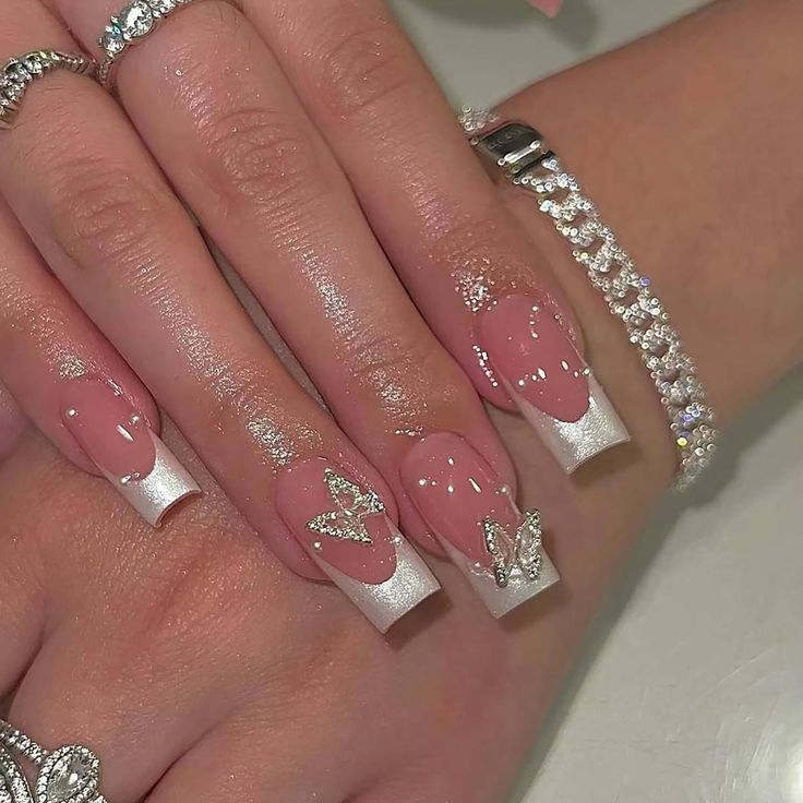 Sophisticated Nude and White Nail Design with Glamorous Butterfly Accents.