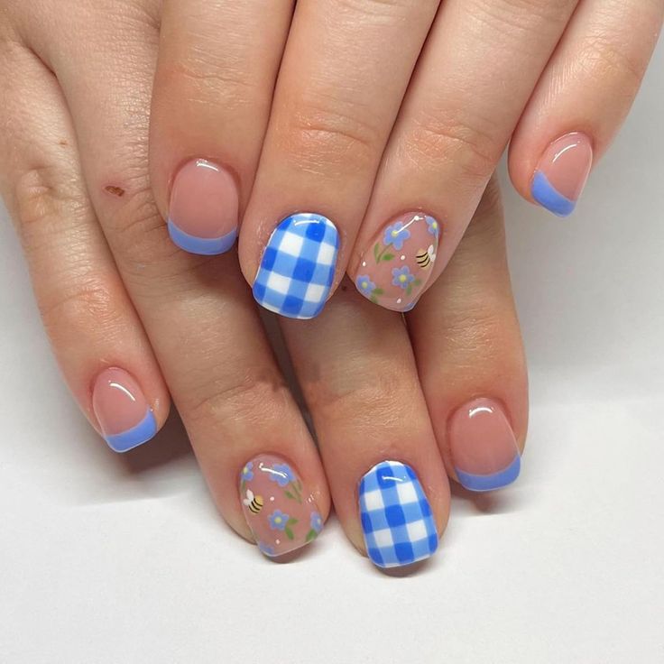 Whimsical Spring Nail Design with Pastel Blue Accents and Playful Patterns.