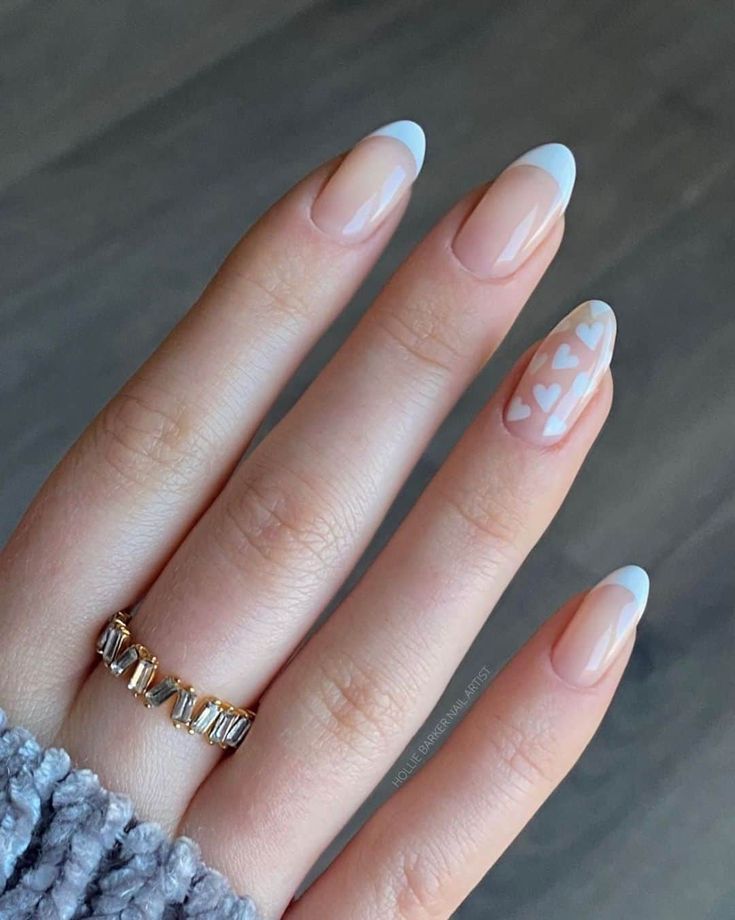 Elegant Nail Design: Soft Nude Base with Delicate White French Tips and Charming Heart Accents.