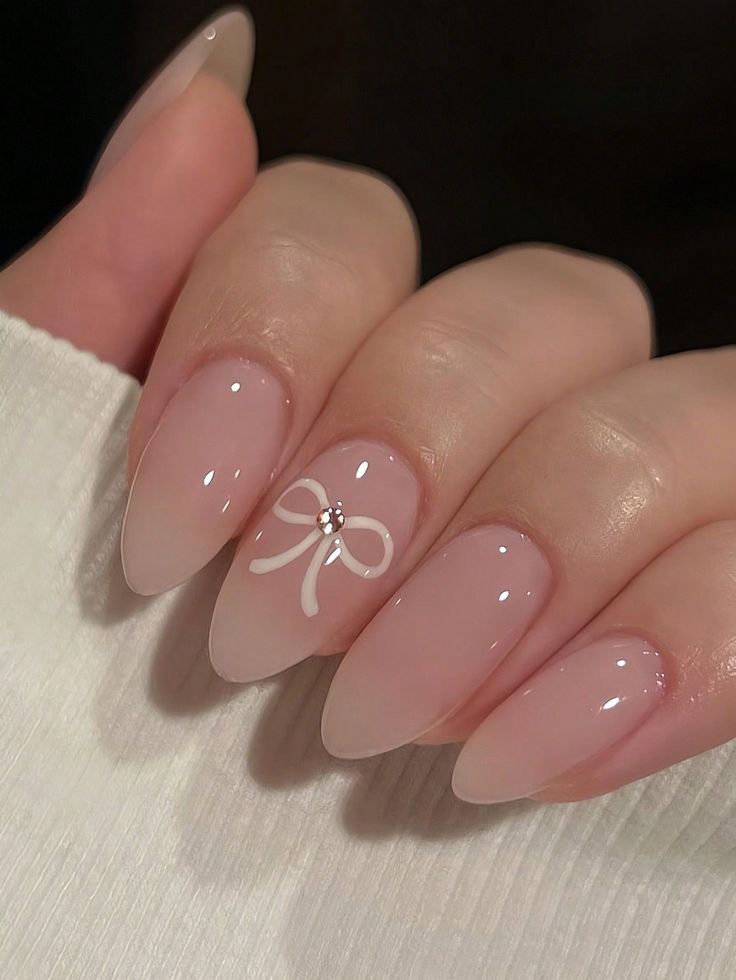 Chic Ombre Nail Design with Delicate Bow and Glossy Finish for Special Occasions.