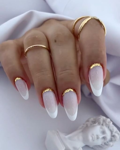 Sophisticated Almond-Shaped Ombre Nails with Gold Accents and Minimalist Rings.