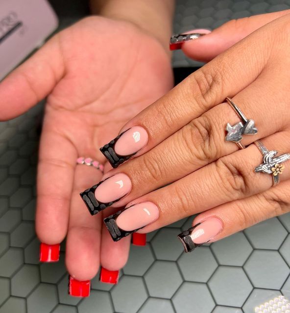 Chic Almond and Square Nail Design with Nude Base, Bold Black Accents, and Bright Red Tips.