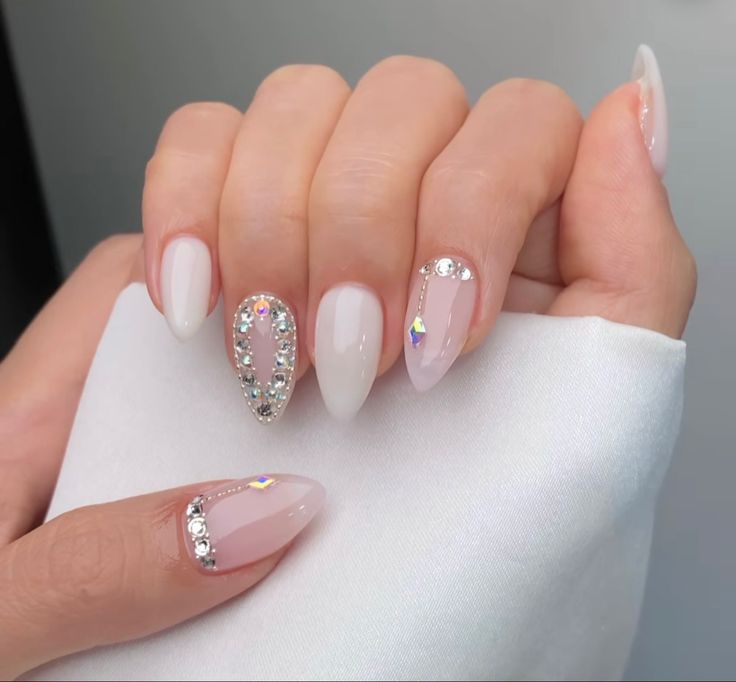 Glamorous Almond-Shaped Nail Design with Translucent Pink Base and Sparkling Embellishments.