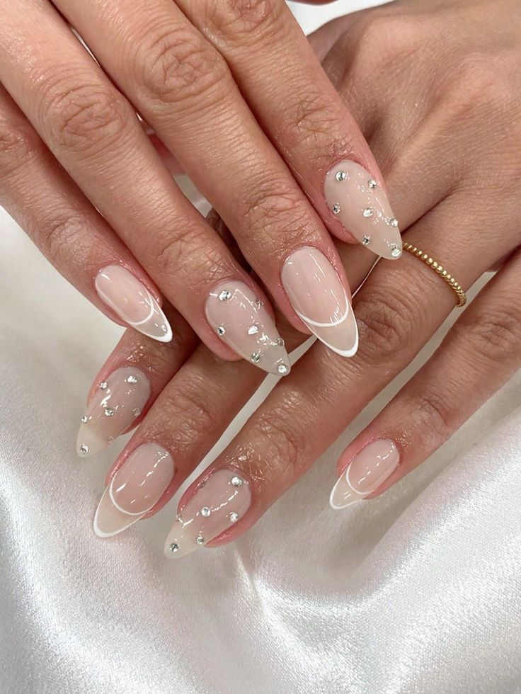 Sophisticated Nude and White Nail Design with Sparkling Embellishments