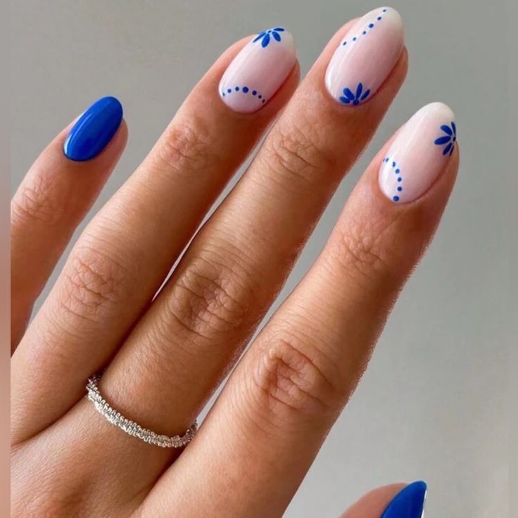 Chic Nail Design: Delicate Pink and Bold Blue Floral Accents for a Sophisticated Look.