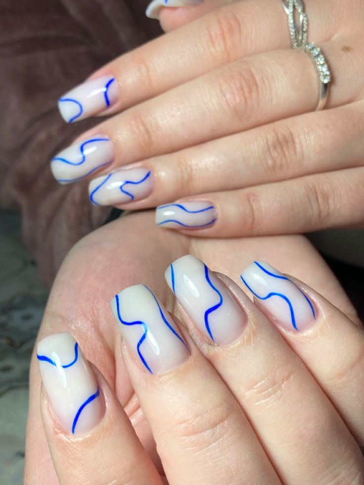 Chic Translucent Nail Design with Flowing Blue Lines: A Modern Minimalist Aesthetic.