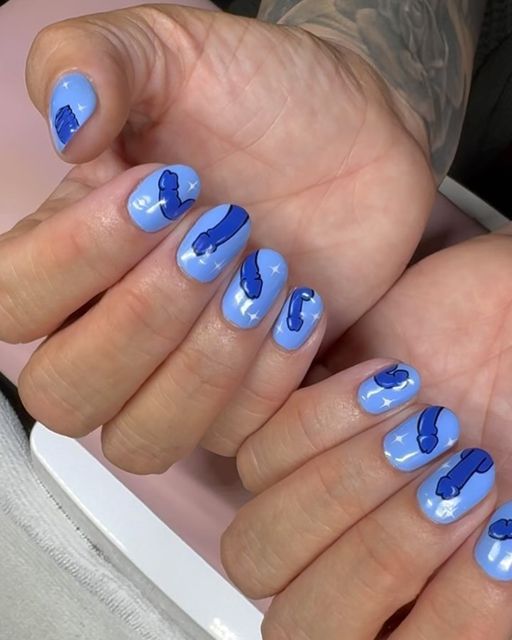 Whimsical Blue Nail Design: Soft Base with Striking Illustrations for a Playful Statement.