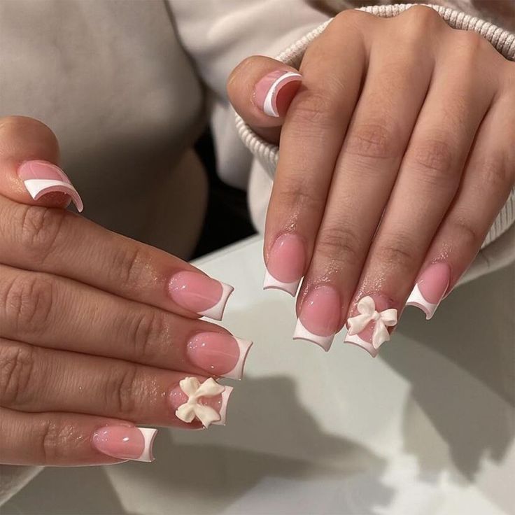 Chic Soft Pink and White Nail Design with Sculpted Bow Accents.