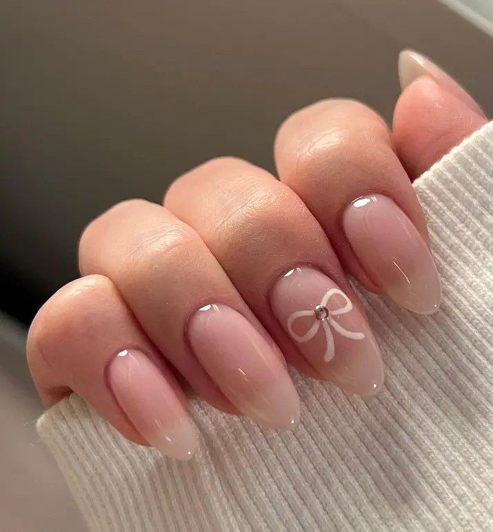 Elegant Ombre Nails with Subtle Bow Design and Gem Accent