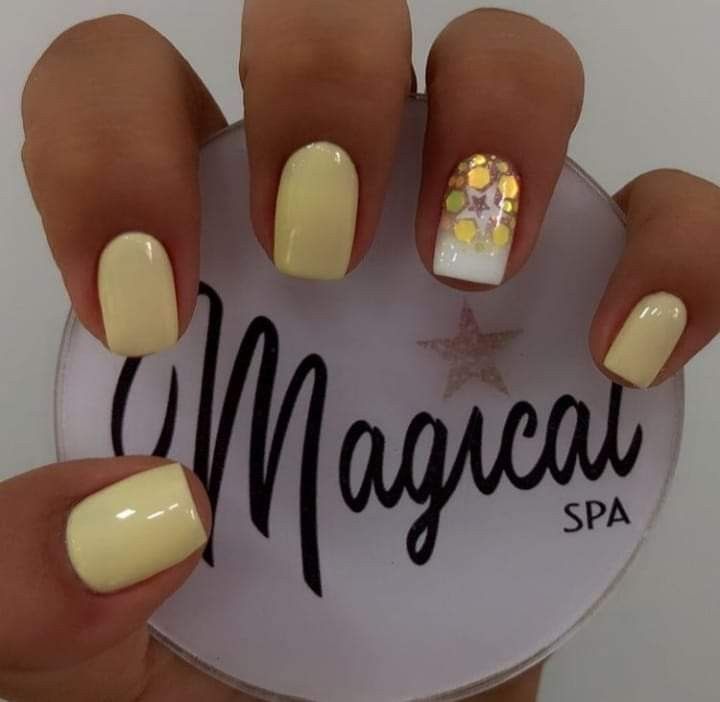 Vibrant Cheerful Yellow Glossy Manicure with Whimsical Gold Star Accents.