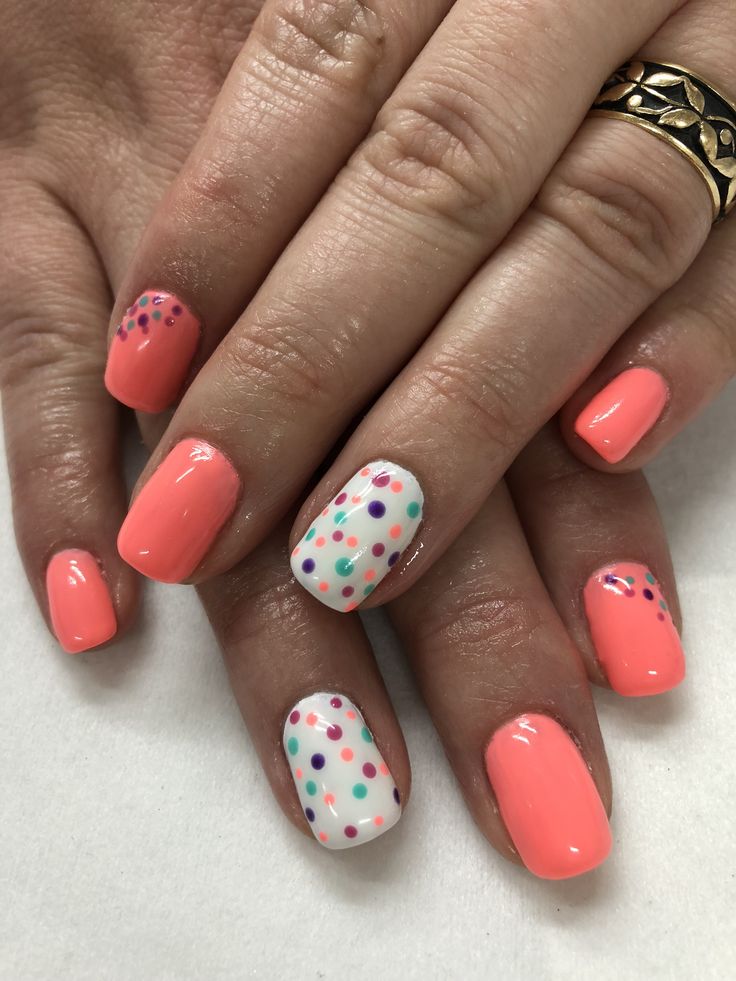 Cheerful Coral Nail Design with Playful Polka Dots and Whimsical Accents.