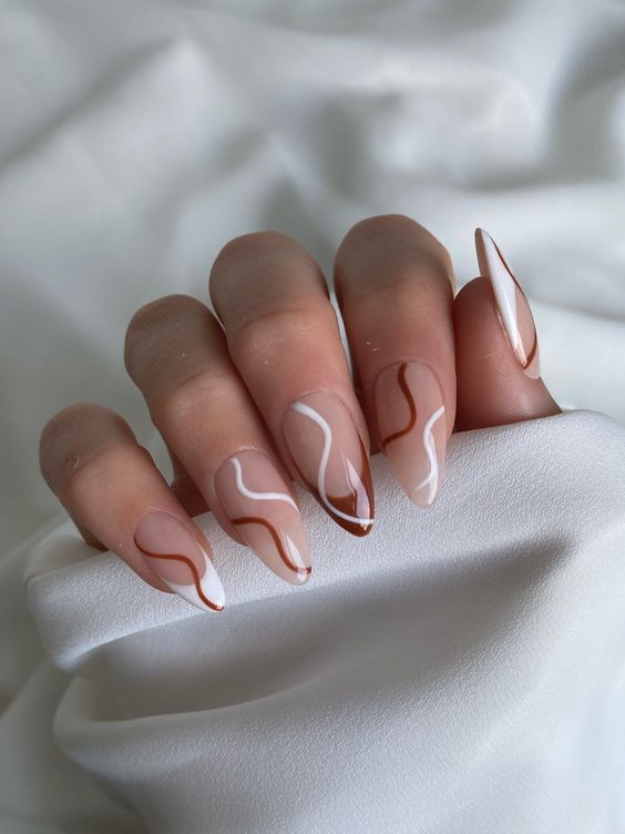 Chic Nude and White Nail Design with Warm Brown Swirls for a Modern Aesthetic.