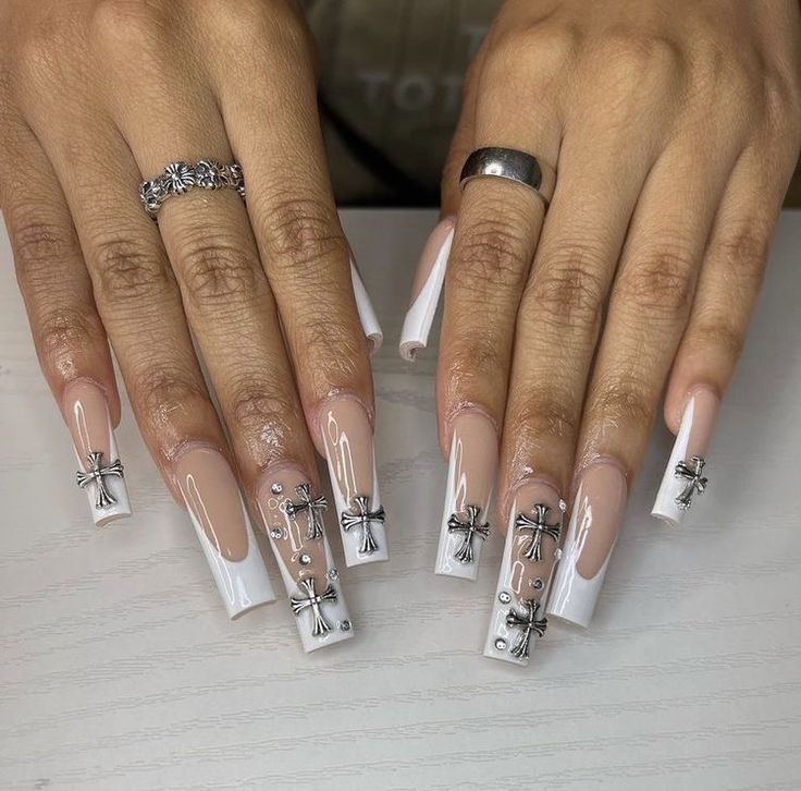 Sophisticated Stiletto Nail Design: Nude and White Polish with Glamorous Silver Accents.