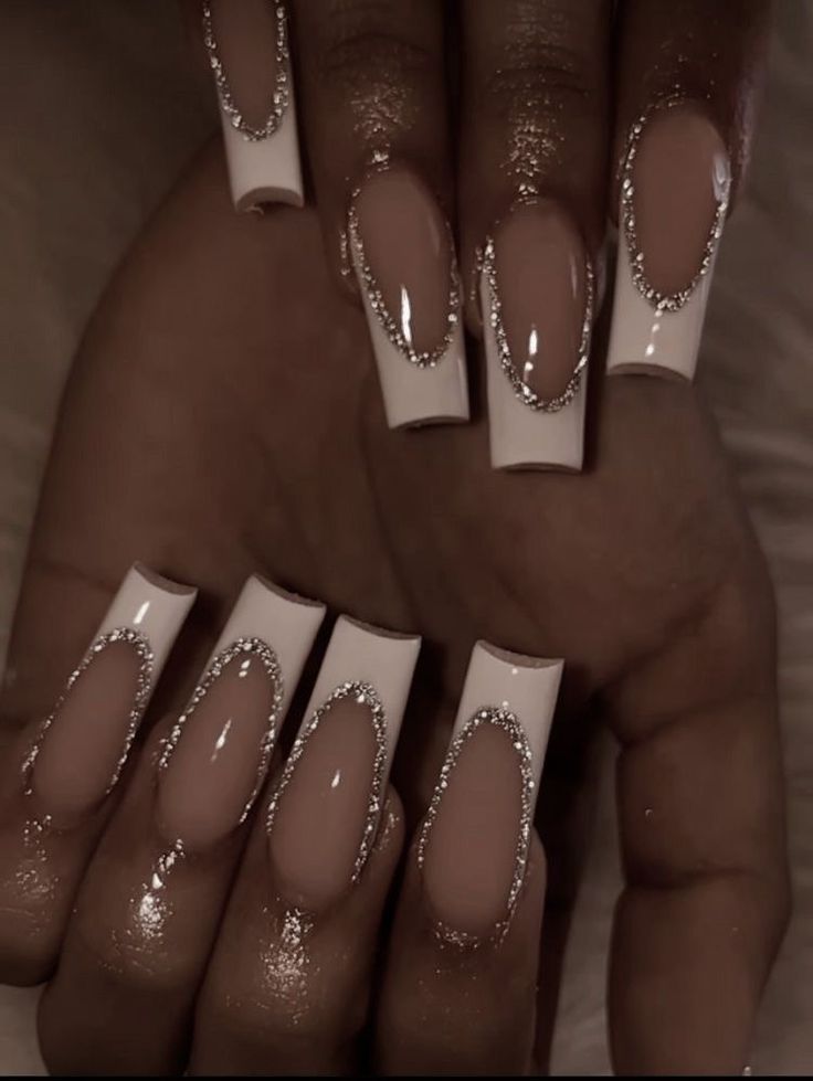 Sophisticated Nail Design: Modern French Tips with Glamorous Rhinestone Accents.