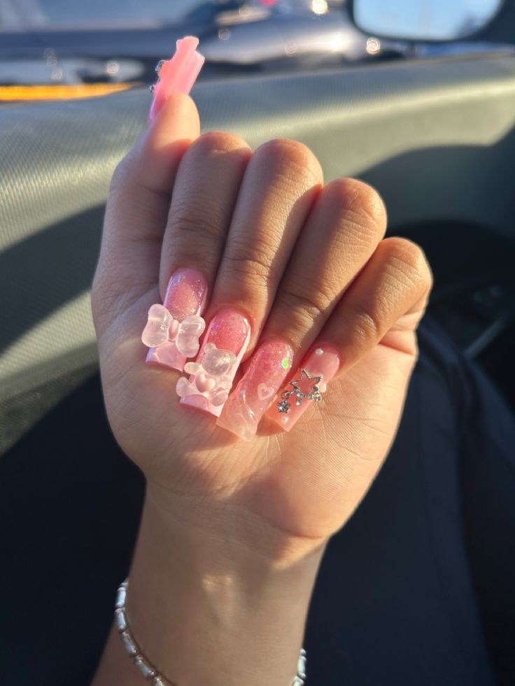 Playful Pink Nail Design with Embellished Sculpted Shapes and Sparkling Accents.