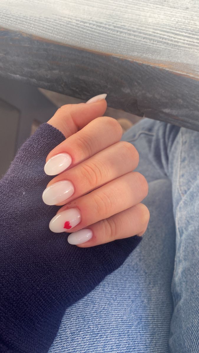 Chic Almond Nail Design with Gradient Nude-Pink and Playful Red Heart Accent.