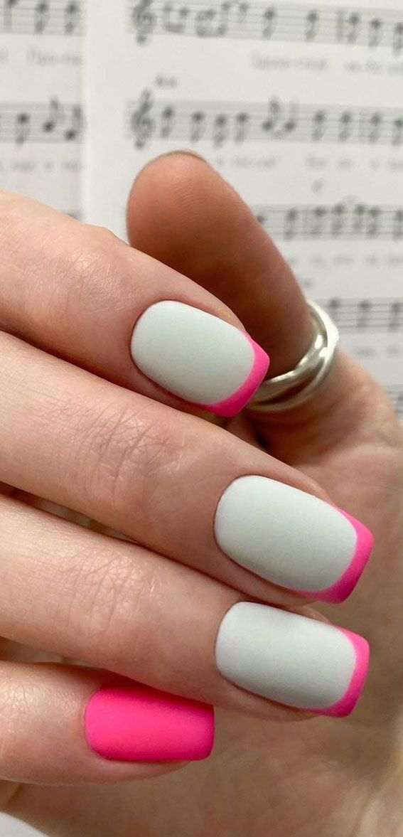 Trendy Matte Nail Design: Soft White Base with Vibrant Pink Tips for a Striking Look.